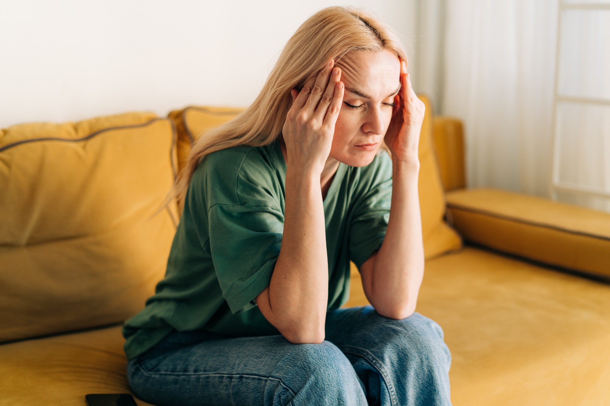 The woman suffers from a headache. Problems and stress affect a person.