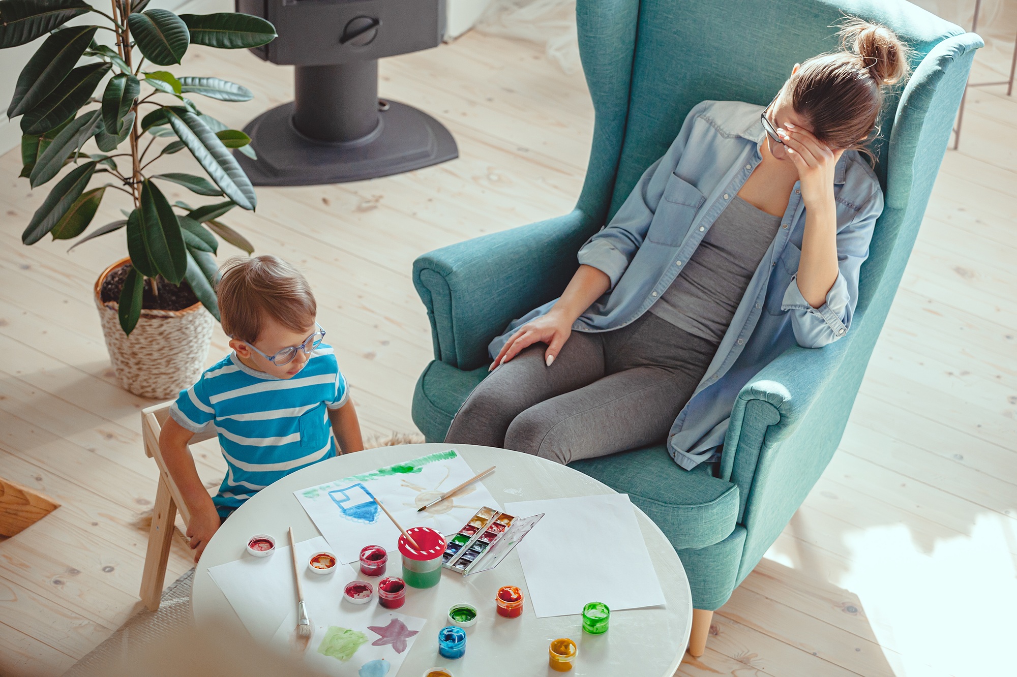 Tired Mother and child with autism paint watercolor together at