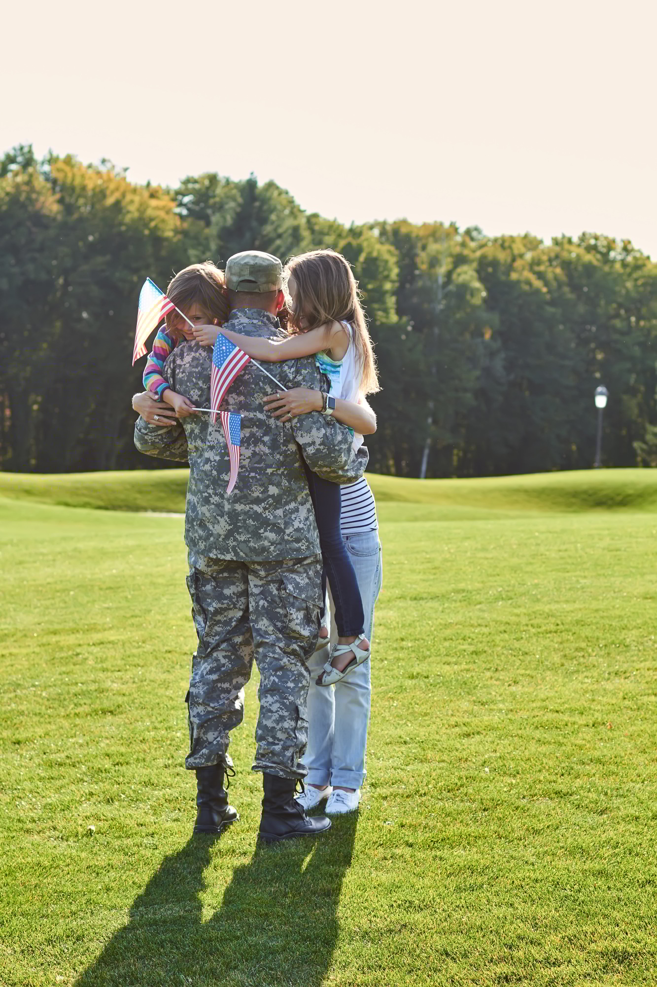 Soldier reunite with his family outdoors.
