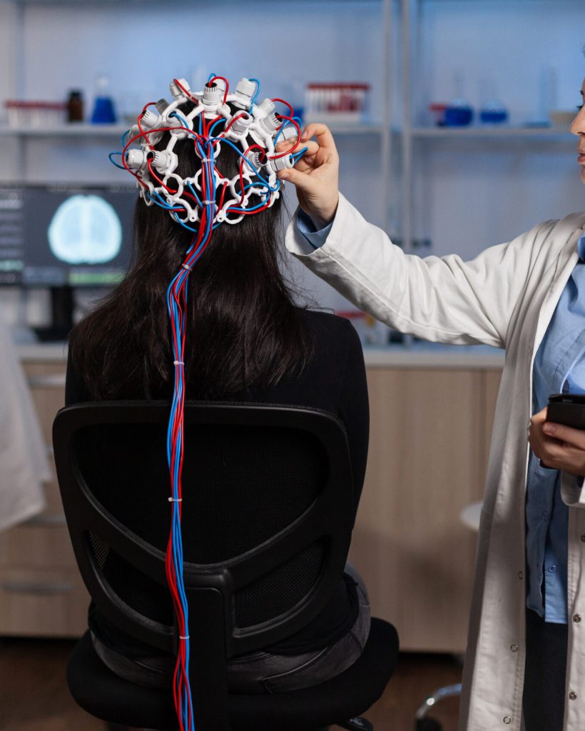 Specialist neurologist doctor monitoring brain evolution of patient with eeg headset on head during neuroscience experiment in modern laboratory. Physician researcher analyzing nervous system activity